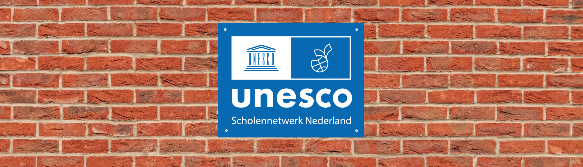 Unesco-scholenbordje op muur