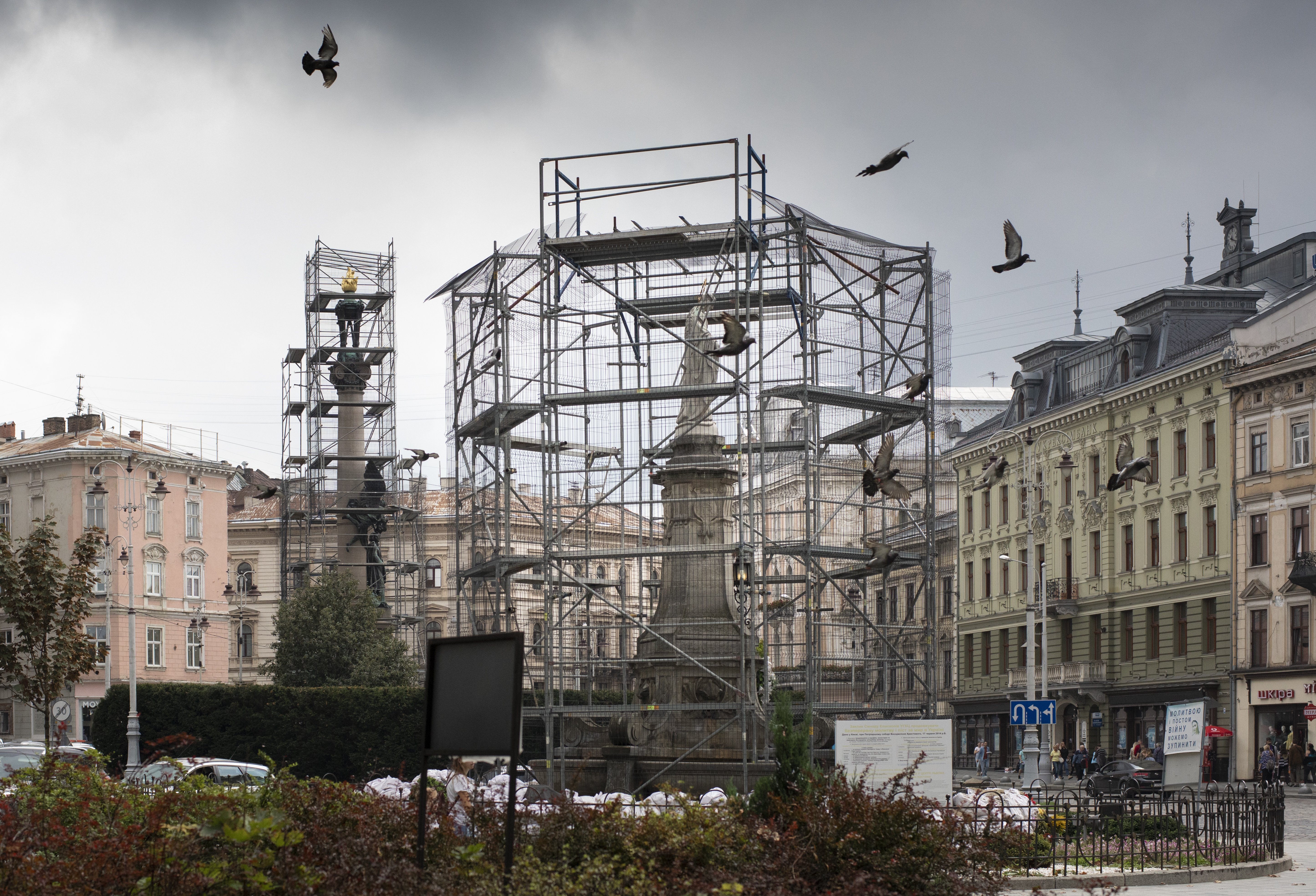Beelden op een plein in Lviv, Oekraïne worden ingepakt met stellages, waartegen zandzakken kunnen worden aangeracht. 