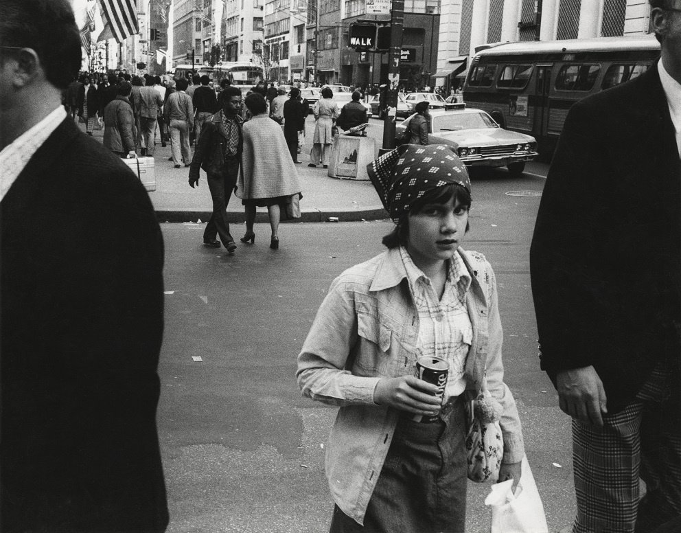 foto van een jong meisje op straat uit 1976 in New York. Ze heeft een blikje cola vast.