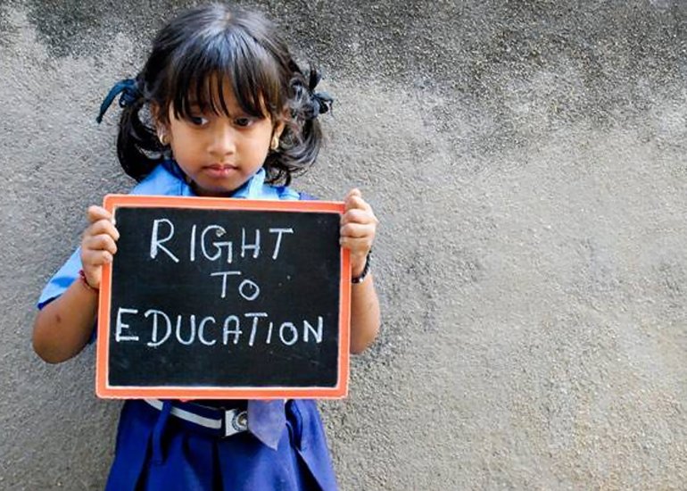 Een meisje houdt een bordje op met daarop de tekst 'Right to Education'. 