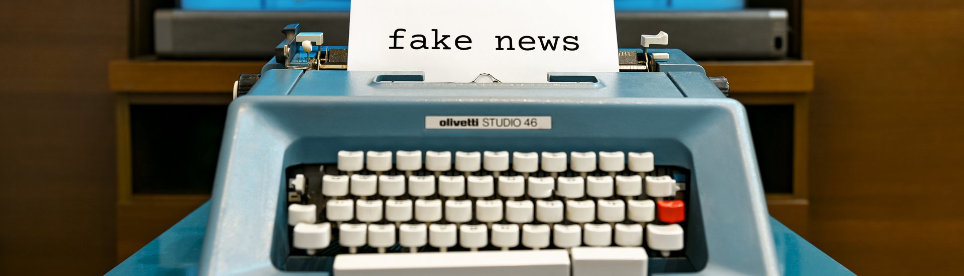 typemachine met een papier erin dat de tekst 'fake news' toont.