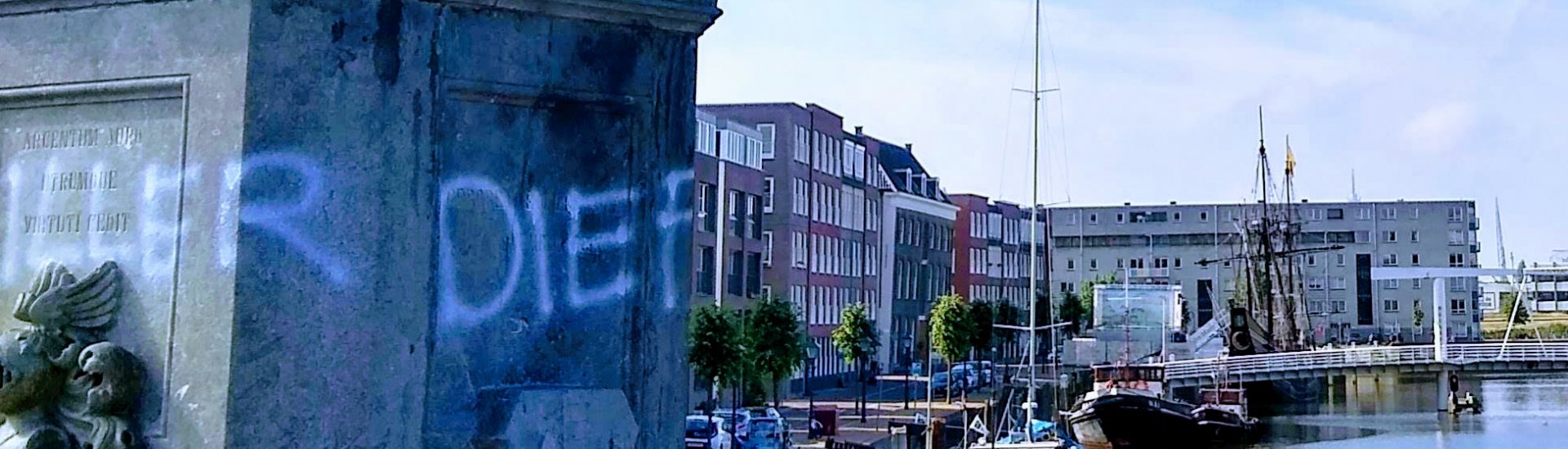 Bekladding van het standbeeld van Piet Hein in Delfshaven, Rotterdam. Op de achtergrond het V.O.C. Zeemagazijn (Kamer Delft) en het replica V.O.C.-schip 'de Halve Maen'. 