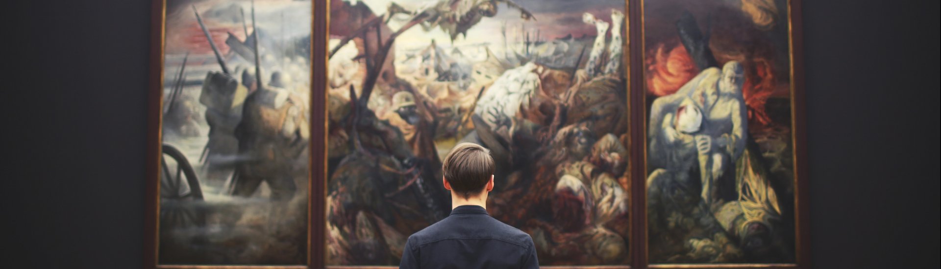 Een man bekijkt een schilderij in een museum