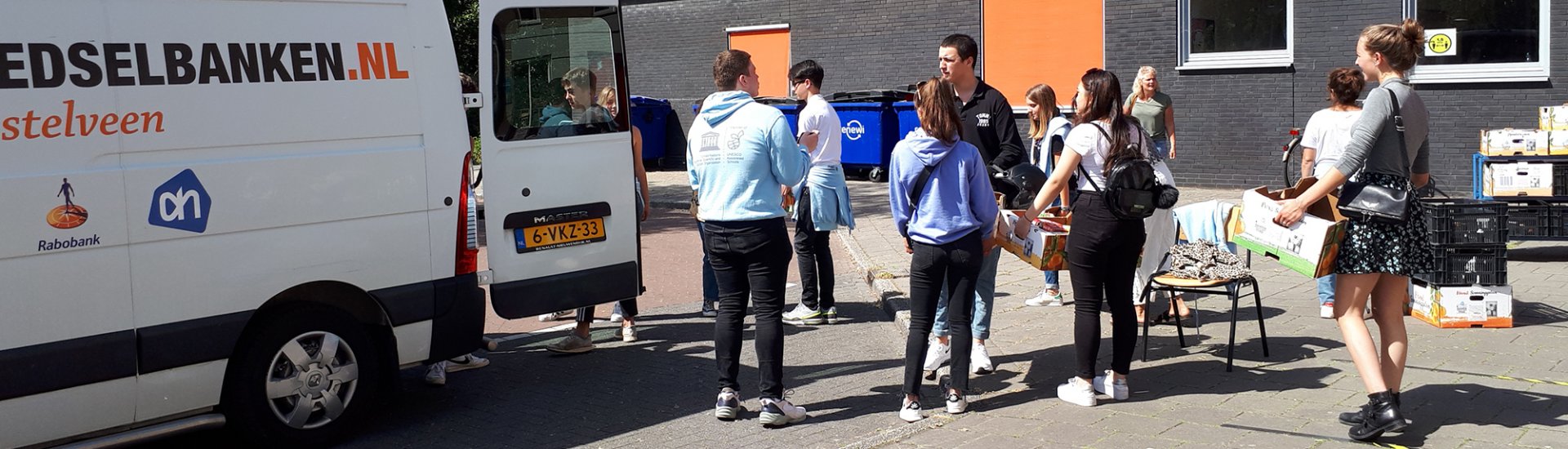 Leerlingen laden de opbrengst van de actie in een busje van de Voedselbank.