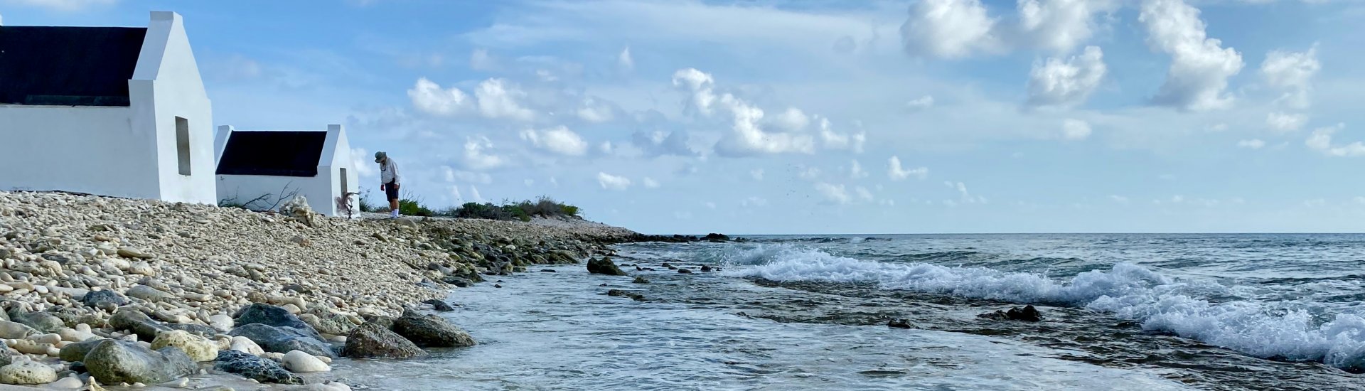 Het strand van Bonaire bestaat hier uit stukjes koraal. Ook zijn kleine slavenhuisjes te zien. 