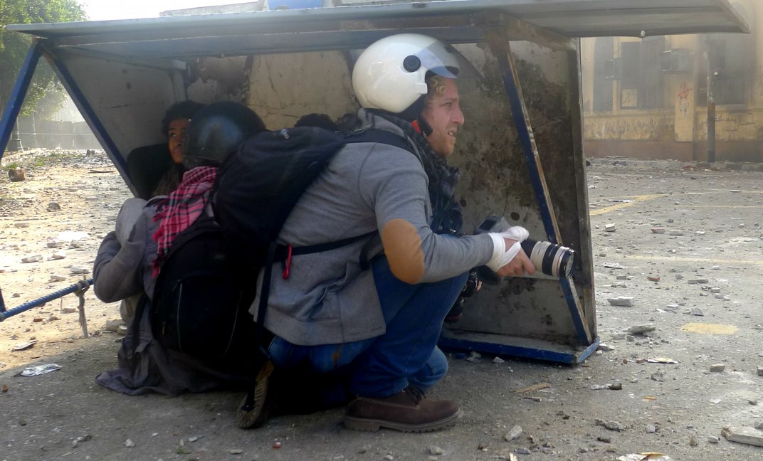 Een fotojournalist zoekt dekking tijdens een demonstratie in Egypte. (Foto: CC/Flickr.com |Alisdare Hickson)