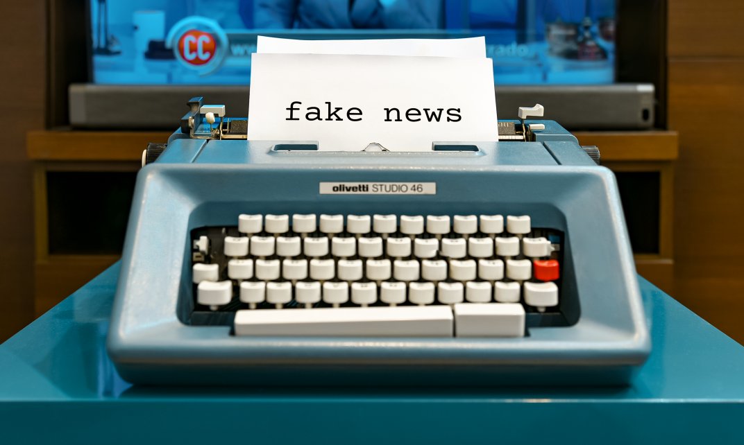 typemachine met een papier erin dat de tekst 'fake news' toont.