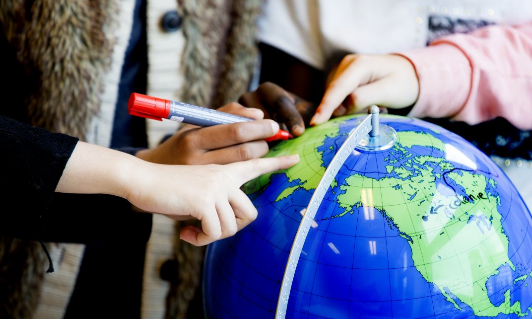 Kinderen maken een lesopdracht met behulp van een wereldbol. (Foto: Nederlandse Unesco Commissie | Arenda Oomen)