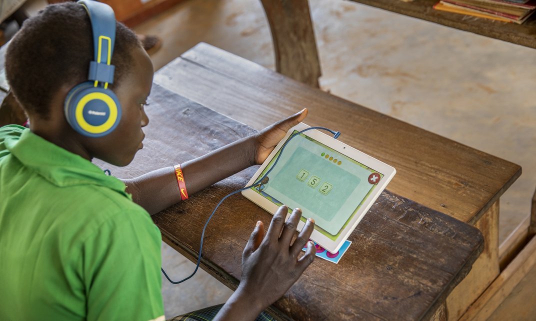 In het project ‘Can’t wait to Learn’ leren kinderen in conflictgebieden lezen, schrijven en rekenen door het spelen van educatieve games op tablets. (Foto: War Child).