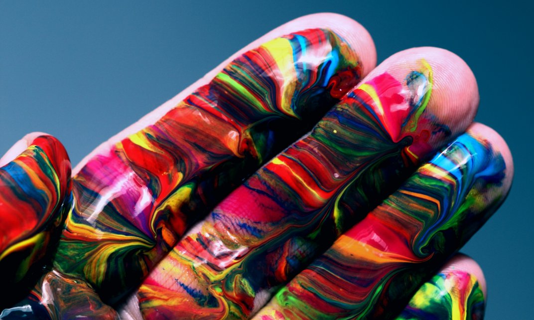 Een hand vol met honderden kleuren verf.