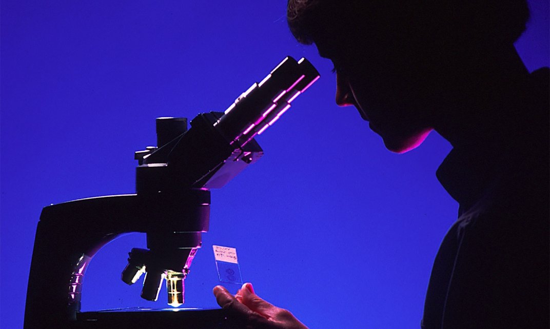 Vrouwelijke wetenschapper kijkt door een microscoop. (Foto: skeeze | CC/Pixabay.com)