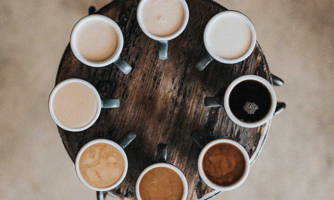 Foto toont diversiteit aan de hand van acht verschillende koffievarianten van zwarte koffie naar koffie met veel melk.
