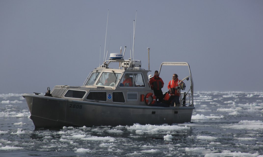 Wetenschappers doen onderzoek op een boot op een ijzige zee.