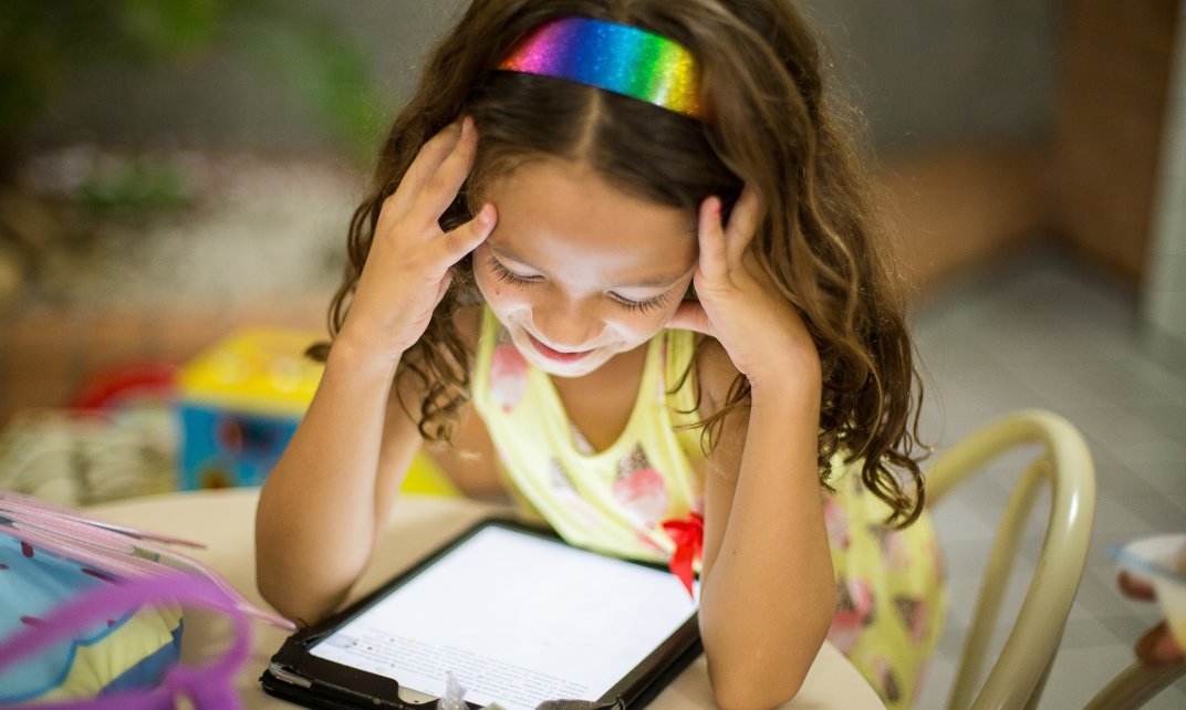 Een meisje leest van een tablet.